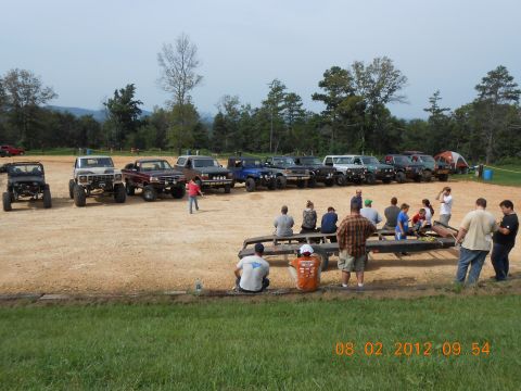 2013 Ford Bronco - A group of people are gathered around several off-road vehicles in an outdoor setting.