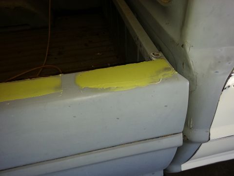 1967 Ford F-100 - Close-up of a truck bed corner showing bodywork in progress with yellow filler.