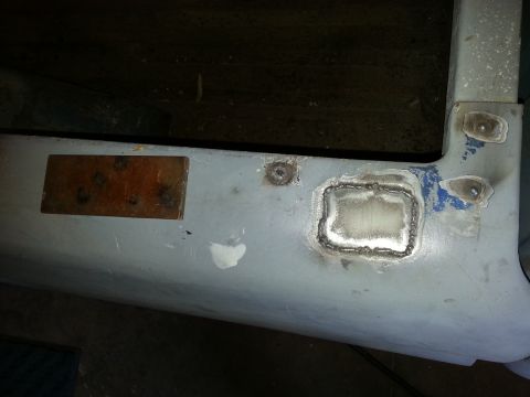 1967 Ford F-100 - Close-up of a gray metal panel showing recent welding repairs and visible bolt holes.
