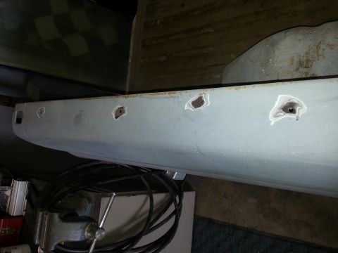 1967 Ford F-100 - A vehicle body panel, possibly a door or fender, is shown with multiple holes drilled into it and secured in a vise.