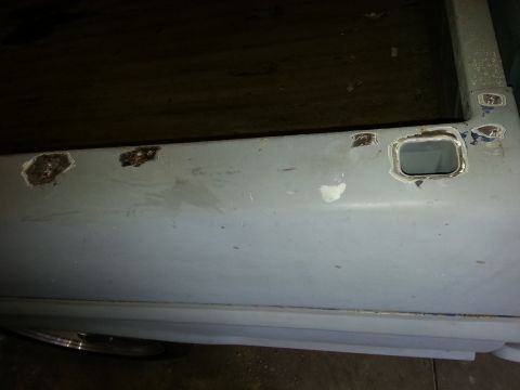 1967 Ford F-100 - A side view of a truck door panel with visible rust damage and preparation for repair.