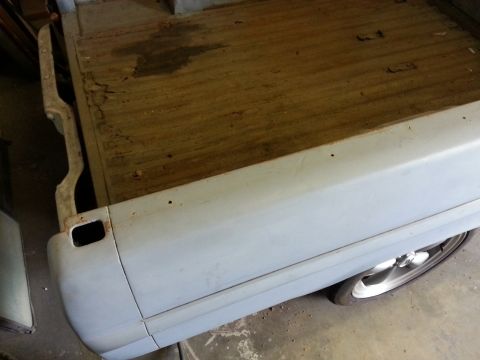 1967 Ford F-100 - The rear bed of a 1967 Ford F-100 pickup truck, shown in primer gray with a wooden floor.