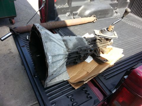 1967 Ford F-100 - Transmission and driveshaft components from a Ford F-100 are laid out in the bed of a pickup truck.