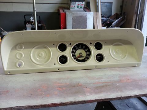 1967 Ford F-100 - A cream-colored dashboard instrument cluster, likely from a 1967 Ford F-100, is displayed on a workbench.