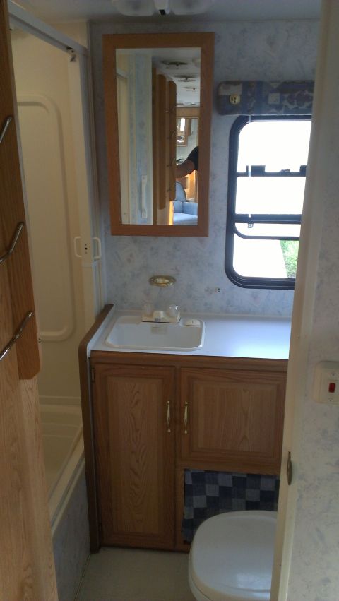 1995 Ford Bronco - Interior view of an RV bathroom, showing a sink, vanity, and shower.