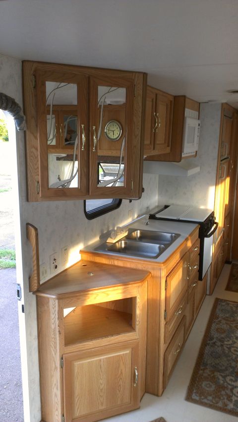 1995 Ford Bronco - Interior view of an RV kitchen showing cabinetry, sink, and appliances.