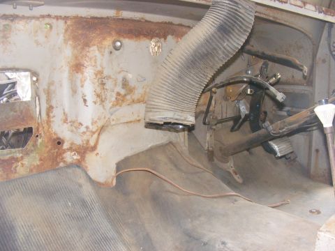 1978 Ford Bronco - The interior of an old vehicle shows significant rust and wear, with exposed metal and a large flexible duct.