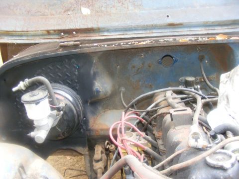 1978 Ford Bronco - Close-up of an engine bay, focusing on the brake booster and associated plumbing.