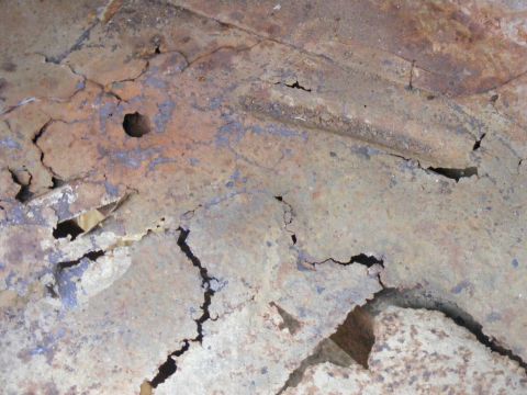 1978 Ford Bronco - The floor of a vehicle shows significant rust and holes, indicating severe deterioration.
