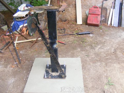 1978 Ford Bronco - A piece of equipment, possibly for an engine hoist, is bolted to a concrete pad outdoors.