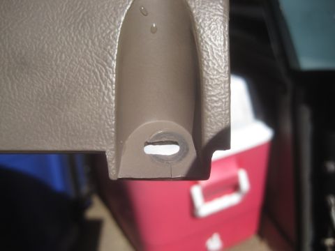 1993 Ford Bronco - Close-up of a tan plastic interior trim piece, possibly from a vehicle.