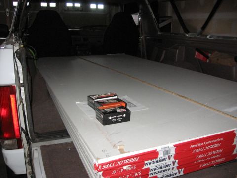 1995 Ford Bronco - Stack of American Gypsum Firelock Type X drywall panels and screws are secured inside a vehicle.