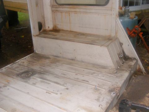 1978 Ford Bronco - The interior floor of a vehicle, showing some wear and tear, with a window visible in the background.