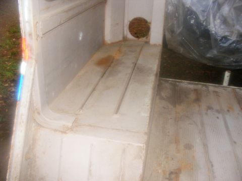 1978 Ford Bronco - The interior cargo area shows a wooden floor and white walls with a circular vent visible.