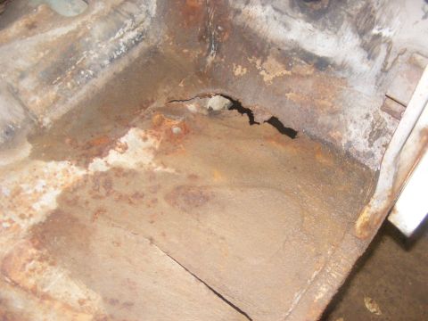 1978 Ford Bronco - Corroded floor pan shows a hole, indicating severe rust damage.