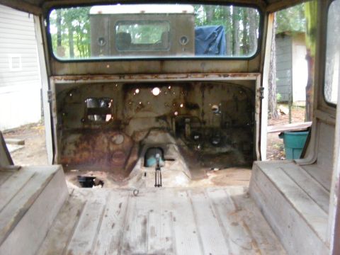 1978 Ford Bronco - The interior of a vehicle, showing rust and wear. Another vehicle is seen in the background.