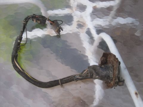1993 Ford Bronco - Wiring harness with connectors and frayed insulation, resting on a textured surface.