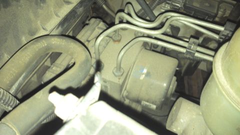 1991 Ford LTD Crown Victoria - Engine bay detail showing a component with brake lines and a hose. Year is not discernible.