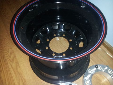 1988 Ford Bronco - Aftermarket wheel with red and blue trim detail, photographed indoors.