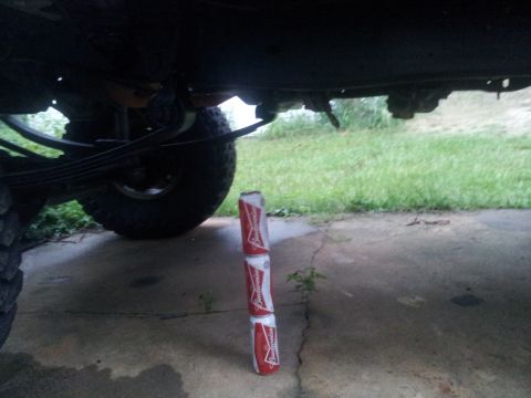 1988 Ford Bronco - A view of a vehicle's undercarriage, with three stacked Budweiser cans visible on the ground.