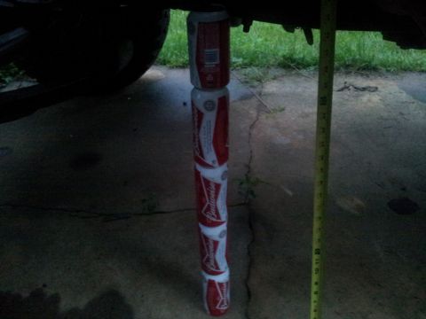 1988 Ford Bronco - A stack of beer cans is used to support a vehicle, with a tape measure for scale.