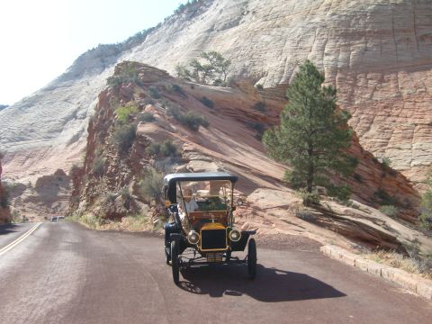 1912 Ford Model T - A vintage 1912 Ford Model T navigates a scenic road through a rocky, mountainous landscape.