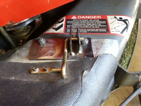 1995 Ford Bronco - A close-up view of a lawn mower's deck, showing a safety warning label about the rotating blade.
