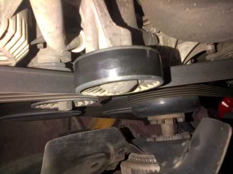 1994 Ford Bronco - This image shows engine components, specifically a belt tensioner and pulleys, with a watermark from SUPERMOTORS.NET.