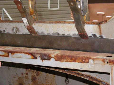 1978 Ford Bronco - Close-up of rusted metal frame sections secured with clamps, indicating ongoing work.