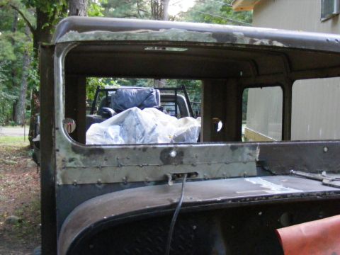 1978 Ford Bronco - The rear of a vintage truck cab, with another vehicle partially covered in the background.