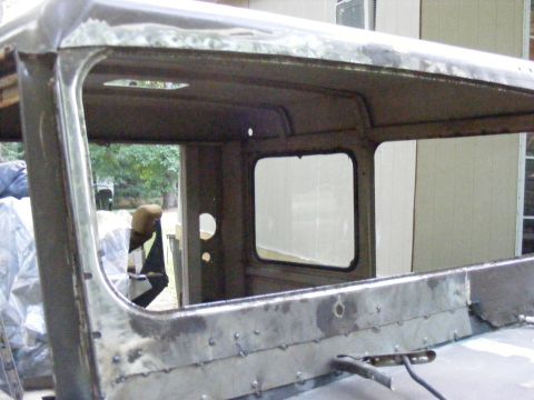 1978 Ford Bronco - The interior of a vehicle cab shows exposed metal and unfinished construction.