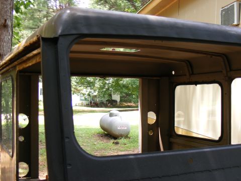 1978 Ford Bronco - The interior of a vehicle is shown, with a propane tank visible through the open doorway in the background.
