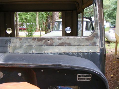 1978 Ford Bronco - View from inside a vintage truck cab, showing the interior and a glimpse of another vehicle outside.