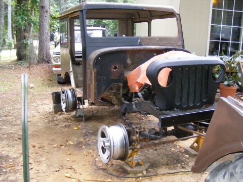 1978 Ford Bronco - Jeep CJ-5 body undergoing restoration, with another vehicle in the background.