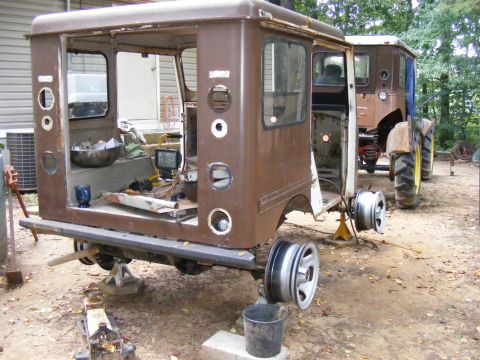 1978 Ford Bronco - Two tractors are parked outside, one is missing wheels and is on jack stands.