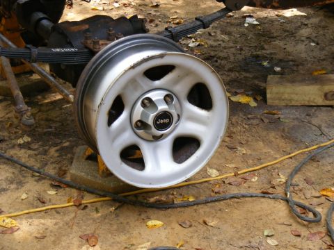 1978 Ford Bronco - A close-up view of a Jeep wheel and its associated axle and suspension components.