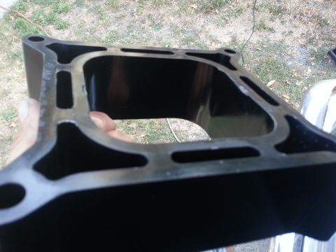 1978 Ford Bronco - Close-up view of a black intake manifold, likely for a V8 engine, being held for inspection.