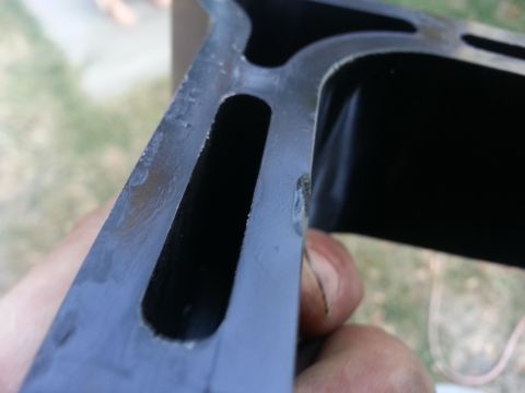 1978 Ford Bronco - Close-up of a dark metal engine part with internal channels, held by a hand.