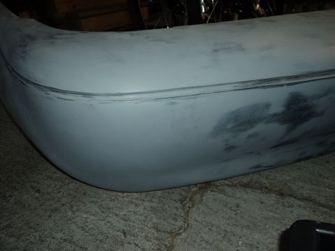 2004 Mercury Grand Marquis - A car bumper, primed and ready for paint, sits on a concrete surface.