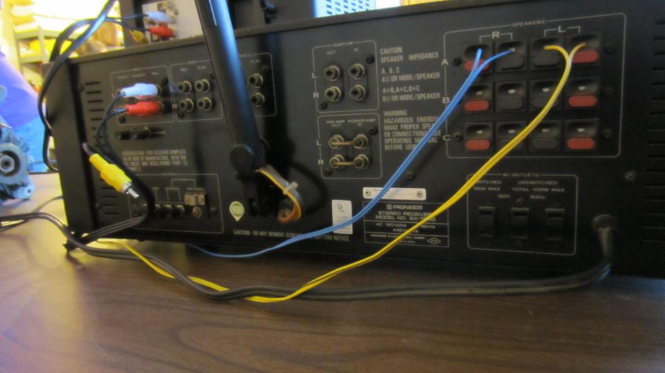 Rear panel of a Pioneer stereo receiver with speaker terminals and blue and yellow wiring