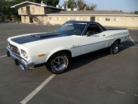 1973 Ford Ranchero - White 1973 Ford Ranchero with black accents and aftermarket wheels sits in a parking lot.