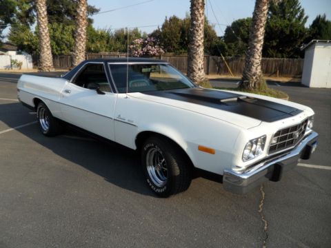 1973 Ford Ranchero - A white 1973 Ford Ranchero with a black hood stripe is parked outdoors.