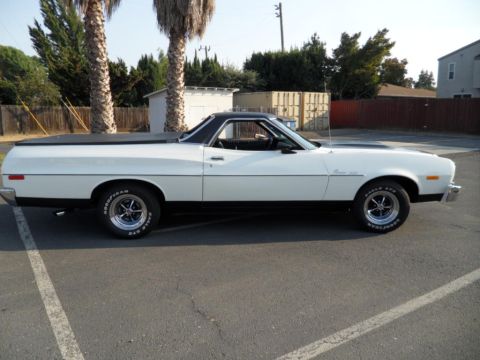 1973 Ford Ranchero - Side profile of a white 1973 Ford Ranchero pickup truck a black vinyl bed cover and racing stripes on the hood.