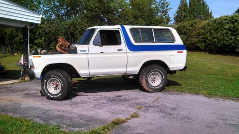 1979 Ford Bronco - This 1978 Ford Bronco is parked in a driveway with the hood up, revealing the engine compartment.