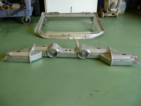 1976 Chevrolet Corvette - Two bare metal car frame components are laid out on a green floor.