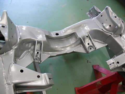 1976 Chevrolet Corvette - A silver painted car frame is shown supported by red jack stands.