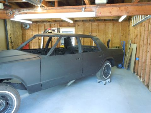 2001 Ford Crown Victoria - Car body undergoing restoration in a garage setting.
