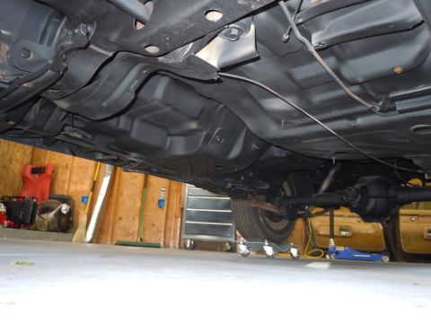 2001 Ford Crown Victoria - The undercarriage of a vehicle is shown, with a focus on the drivetrain and fuel system components.