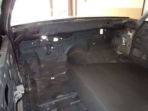 2001 Ford Crown Victoria - The interior of a car is shown stripped down to its metal components, revealing the floor pan and dashboard structure.