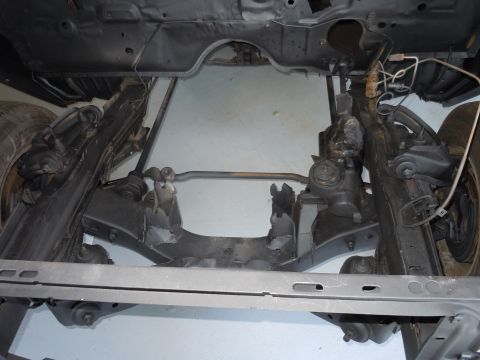 2001 Ford Crown Victoria - Undercarriage view showing the front suspension and steering assembly of a vehicle.